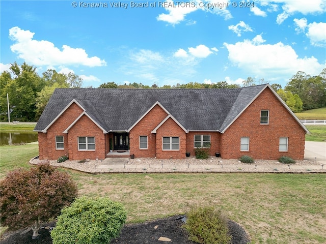 view of front of house featuring a water view and a front lawn