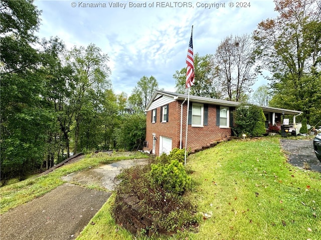 view of side of home with a yard and a garage