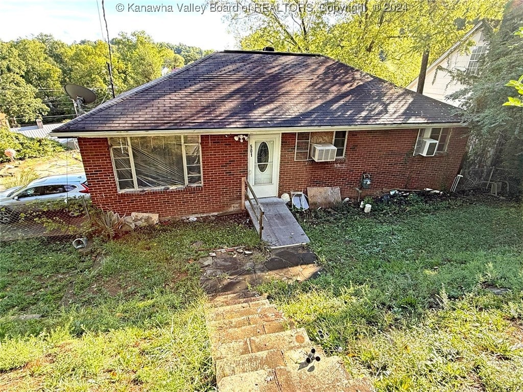 view of front of house featuring cooling unit and a front lawn