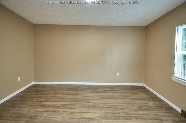 spare room featuring a textured ceiling and hardwood / wood-style floors