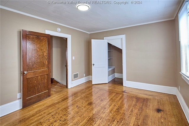 unfurnished room featuring ornamental molding and hardwood / wood-style flooring