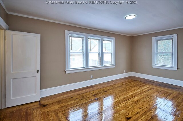 unfurnished room with hardwood / wood-style flooring and crown molding