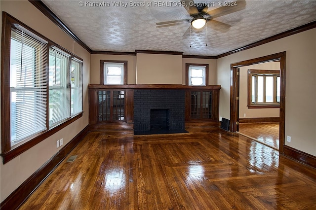 unfurnished living room featuring ornamental molding, a brick fireplace, ceiling fan, and a textured ceiling