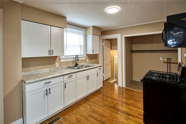 kitchen featuring light hardwood / wood-style floors, white cabinetry, and sink