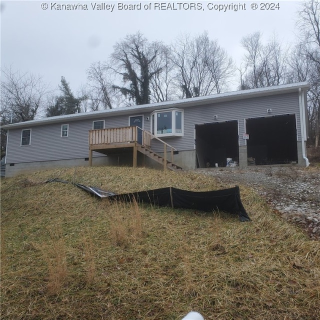 rear view of house with a garage and a deck