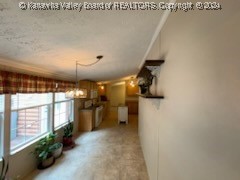 unfurnished dining area featuring a textured ceiling