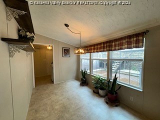 unfurnished dining area with a textured ceiling and lofted ceiling