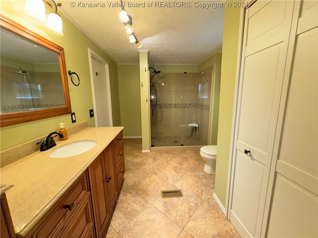 bathroom featuring a textured ceiling, walk in shower, tile patterned floors, vanity, and toilet