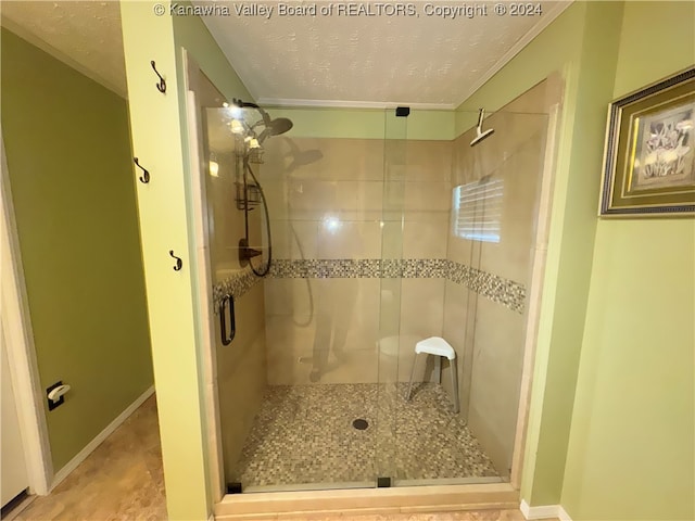 bathroom with a textured ceiling and a shower with shower door