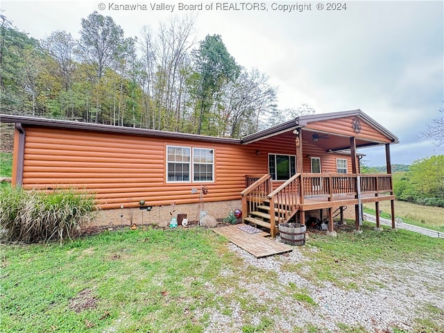 back of house with a wooden deck and a yard