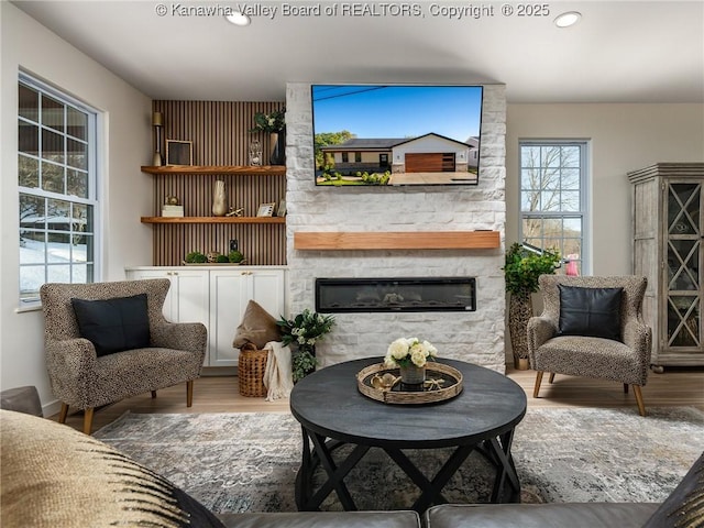 living area with hardwood / wood-style flooring and a fireplace