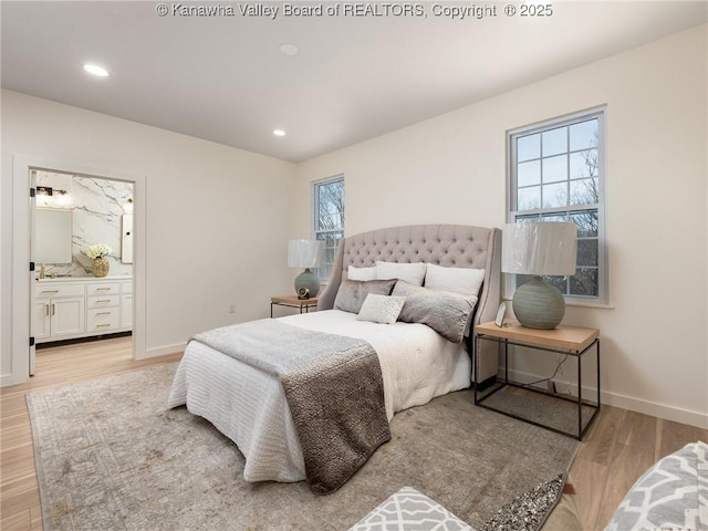 bedroom with light wood-type flooring and ensuite bath