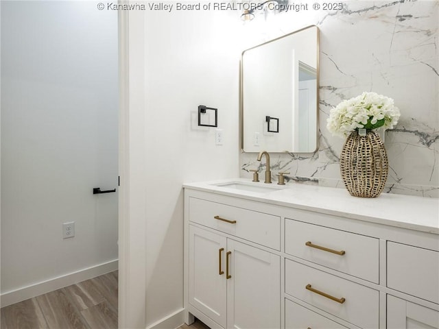 bathroom with hardwood / wood-style flooring, vanity, and decorative backsplash