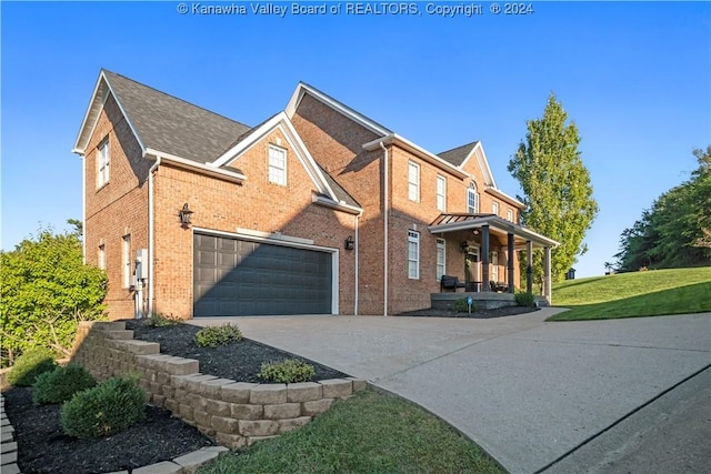 view of front of home featuring driveway, brick siding, an attached garage, a porch, and a front lawn