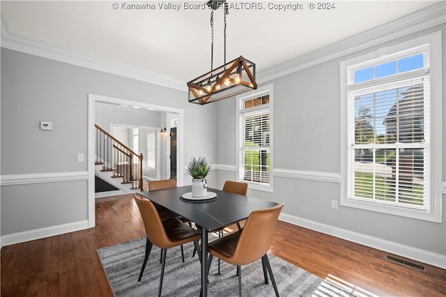 dining area featuring dark hardwood / wood-style floors, a chandelier, and crown molding