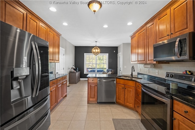 kitchen featuring pendant lighting, light tile patterned floors, sink, kitchen peninsula, and stainless steel appliances