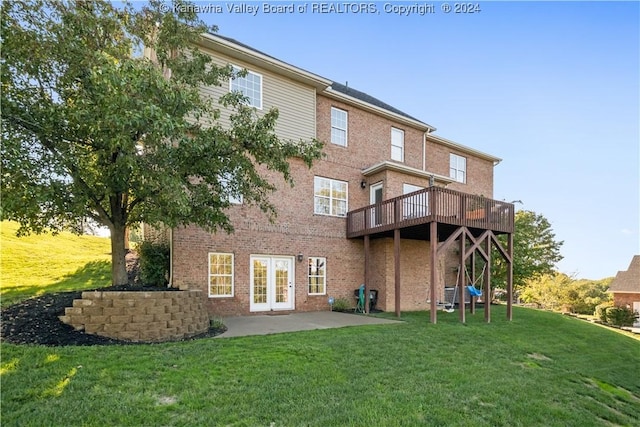 back of house featuring a lawn, a patio, and brick siding