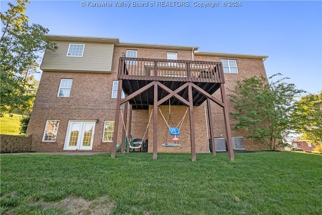 back of house featuring french doors, a deck, a lawn, and central AC