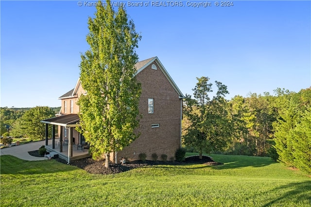 view of side of home with a lawn