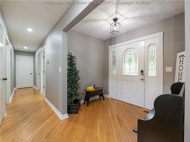 foyer with a textured ceiling and light hardwood / wood-style floors