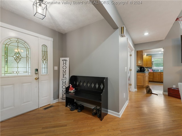 foyer featuring a textured ceiling and light wood-type flooring