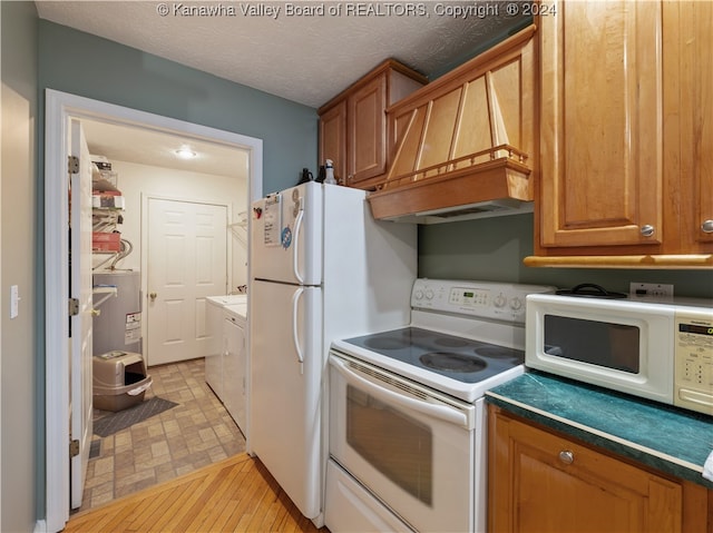 kitchen featuring custom exhaust hood, a textured ceiling, water heater, light hardwood / wood-style floors, and white appliances