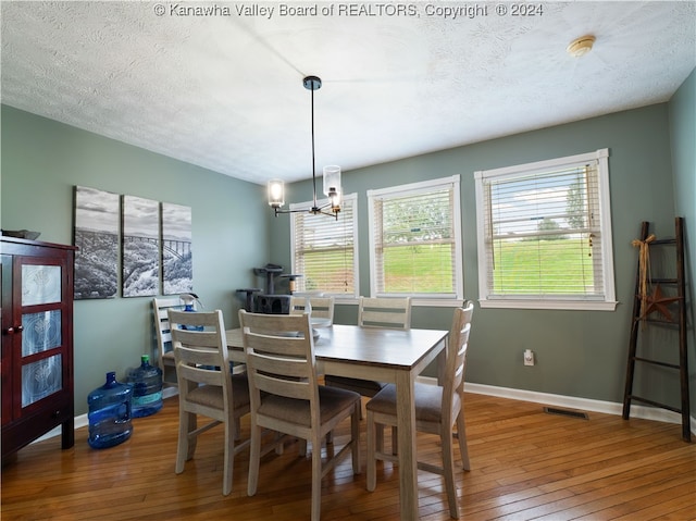 dining room featuring a notable chandelier, a textured ceiling, and hardwood / wood-style floors