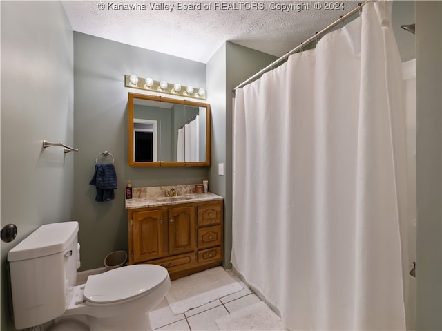 bathroom with a textured ceiling, toilet, vanity, a shower with curtain, and tile patterned floors