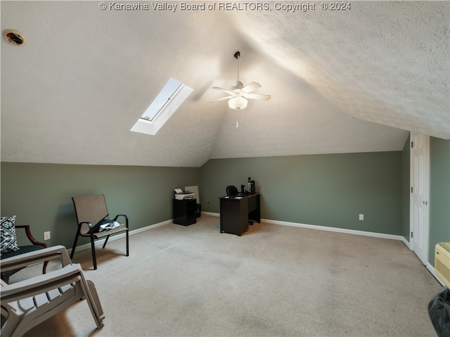 bonus room with lofted ceiling with skylight, ceiling fan, a textured ceiling, and light colored carpet