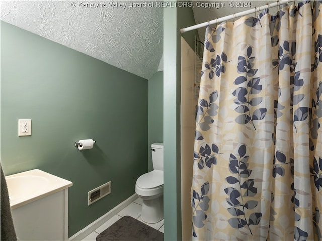 bathroom with a textured ceiling, toilet, vanity, curtained shower, and tile patterned floors