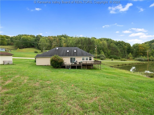 back of house with a deck with water view and a yard