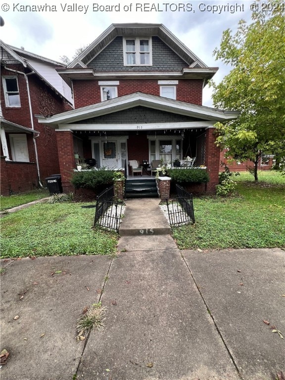 view of front facade with a front yard and covered porch