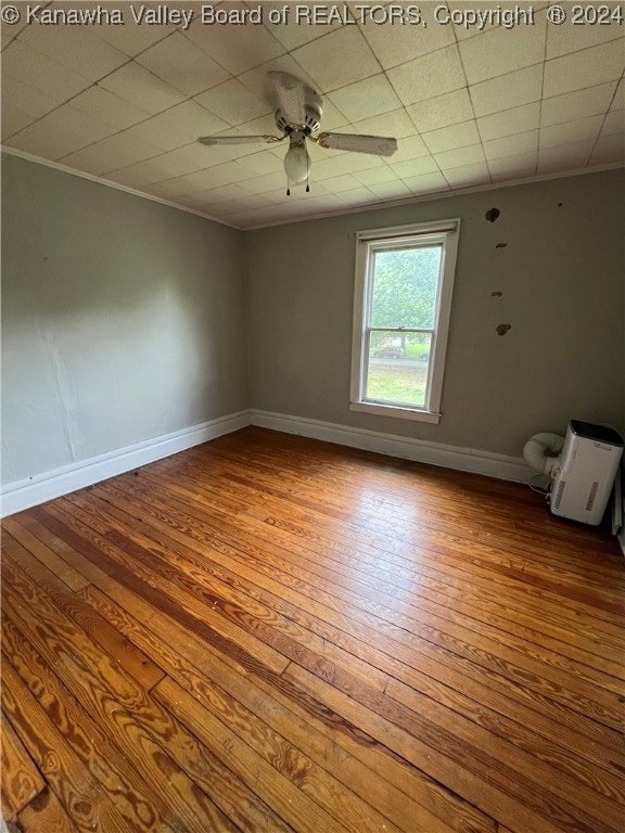 empty room with wood-type flooring, ornamental molding, and ceiling fan