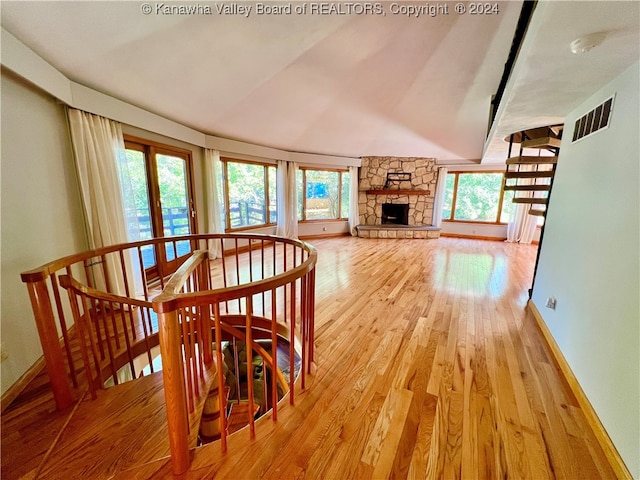 dining room with light hardwood / wood-style floors, vaulted ceiling, and a fireplace