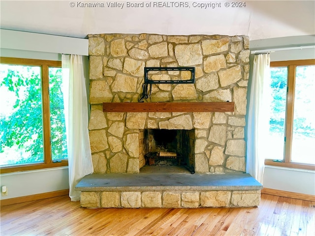 room details with hardwood / wood-style flooring and a stone fireplace