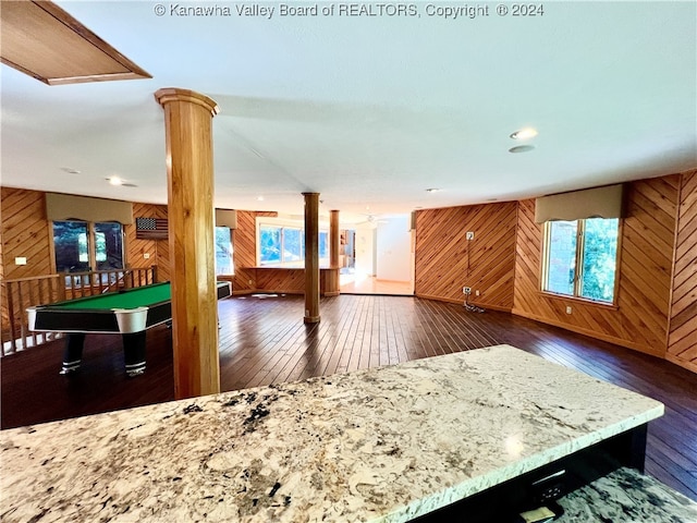 interior space featuring wood walls, dark hardwood / wood-style flooring, and plenty of natural light