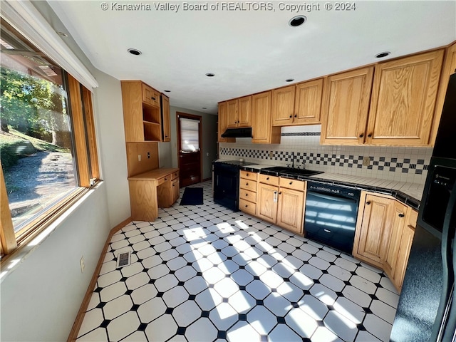 kitchen featuring black appliances, tile counters, tasteful backsplash, and sink