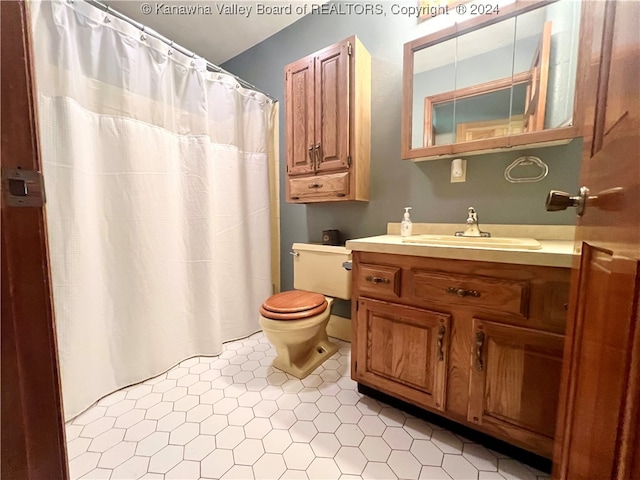 bathroom with a shower with shower curtain, tile patterned flooring, vanity, and toilet