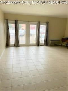 empty room featuring a baseboard heating unit and french doors