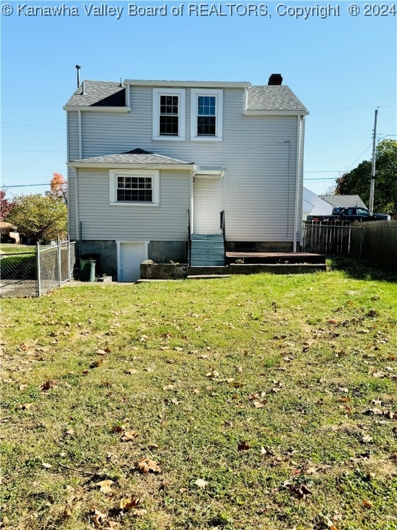 rear view of property featuring a yard