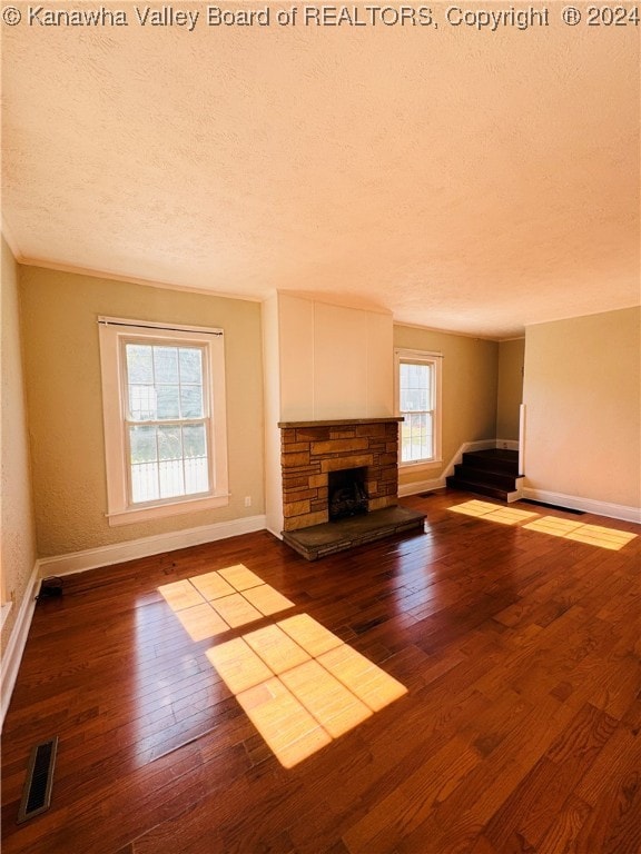 unfurnished living room with a textured ceiling, a fireplace, and hardwood / wood-style flooring