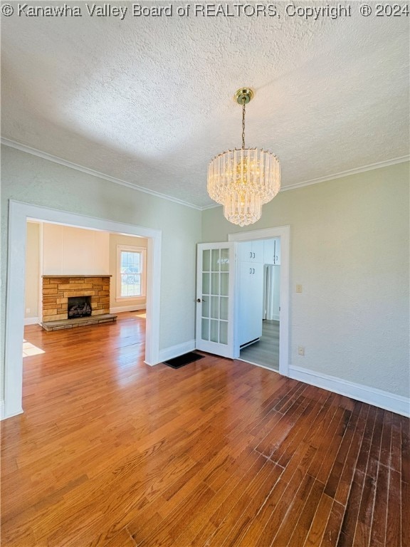 unfurnished dining area with crown molding, hardwood / wood-style floors, and a textured ceiling