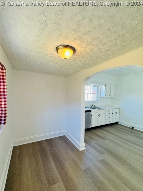 additional living space featuring light hardwood / wood-style flooring, a textured ceiling, and sink