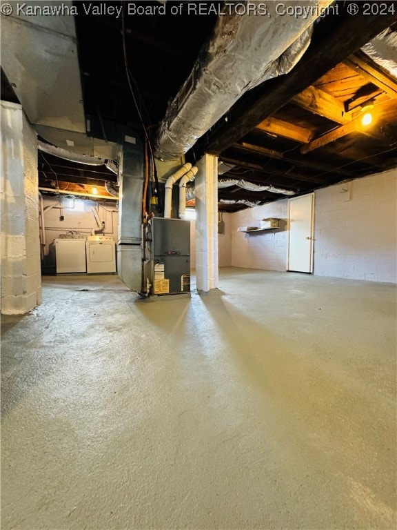 basement with washing machine and dryer and heating unit