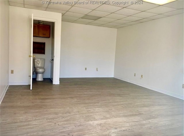 empty room featuring wood-type flooring and a paneled ceiling