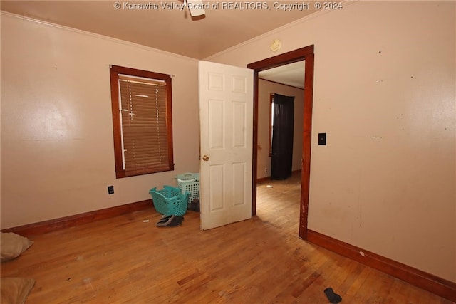 empty room with light wood-type flooring and crown molding