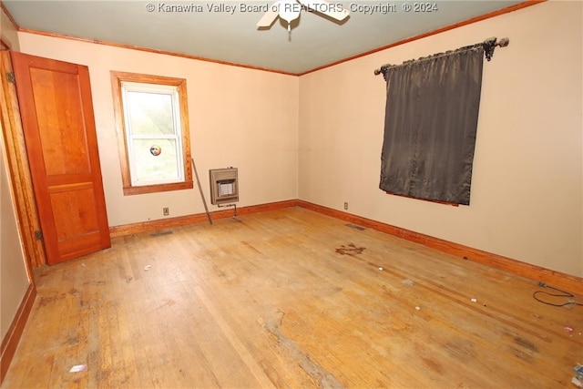 unfurnished room featuring crown molding, ceiling fan, heating unit, and hardwood / wood-style flooring