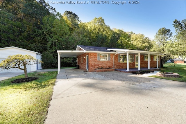 view of front of property featuring a porch, a carport, an outbuilding, a front yard, and a garage