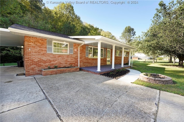 exterior space with a front yard, covered porch, and a carport