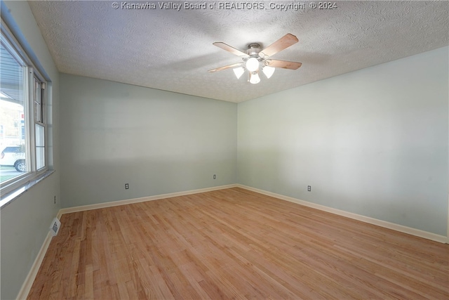 unfurnished room with light hardwood / wood-style floors, a textured ceiling, and ceiling fan